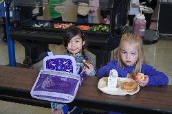 Two girls eat their lunch at Del Rey Elementary School in March 2023.